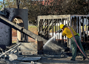 A firefighter works to douse a hotspot following the Spur Fire.