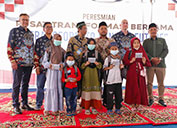 Representatives of PT Freeport Indonesia, the Yatamam foundation and local government pose with five orphan children holding school tuition vouchers that were paid for with proceeds from recycled rebar at the official inauguration of the PTB. 