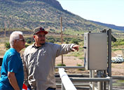 Bayard Mayor Chon Fierro (left) and Stephen Estrada, Laborer/Operator, at the wastewater treatment plant in Hurley, look out over the facility.