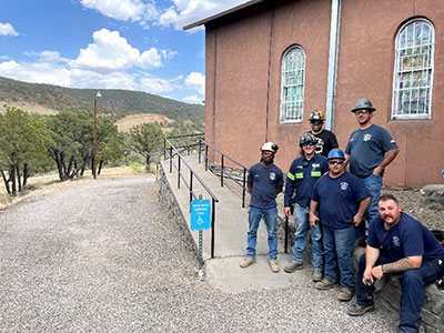 Outside the historic Saint Anthony’s church, Daniel Coyle (back left) stands with the five-person fire response team sent by Morenci.