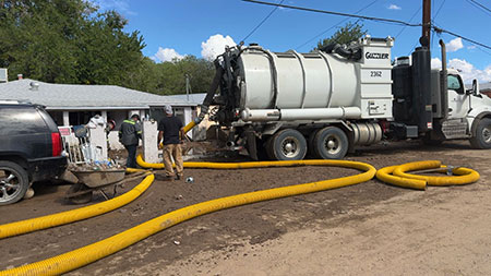 Volunteers from Freeport’s Miami operation used company Guzzler vacuum trucks to help clear mud from flood-ravaged homes in the area.
